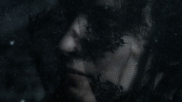 A woman with a black veil underwater